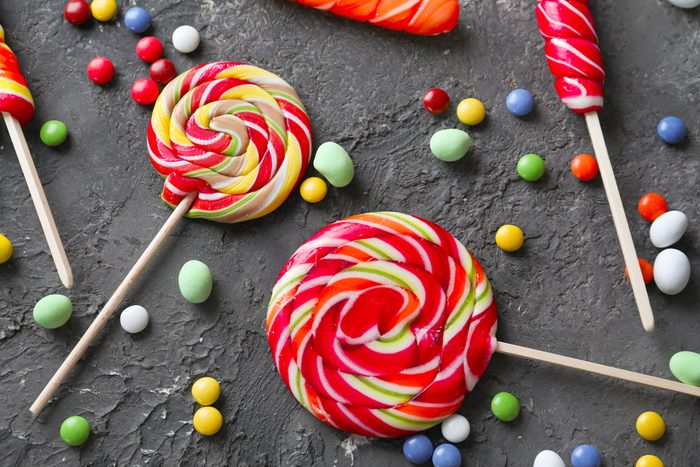 Colorful candies with lollipops on grey textured background