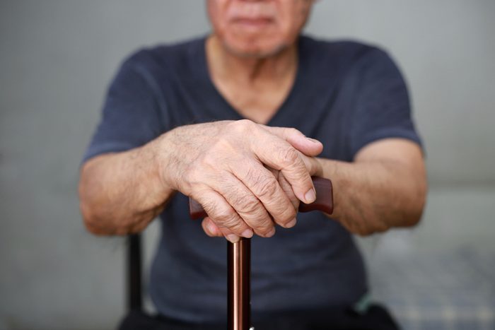 Close up of old man hand with walking stick.