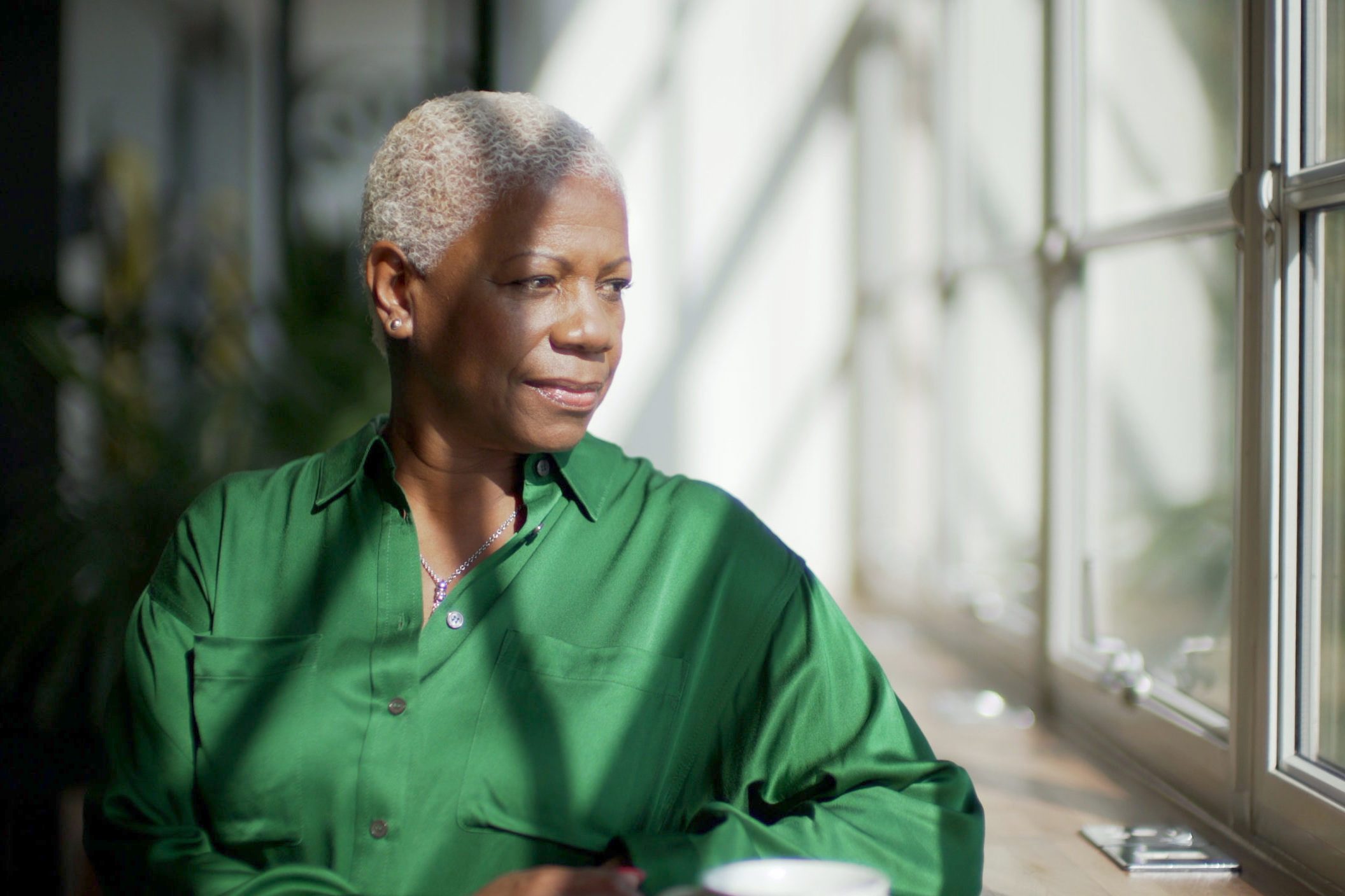 mature woman sitting at home looking out the window