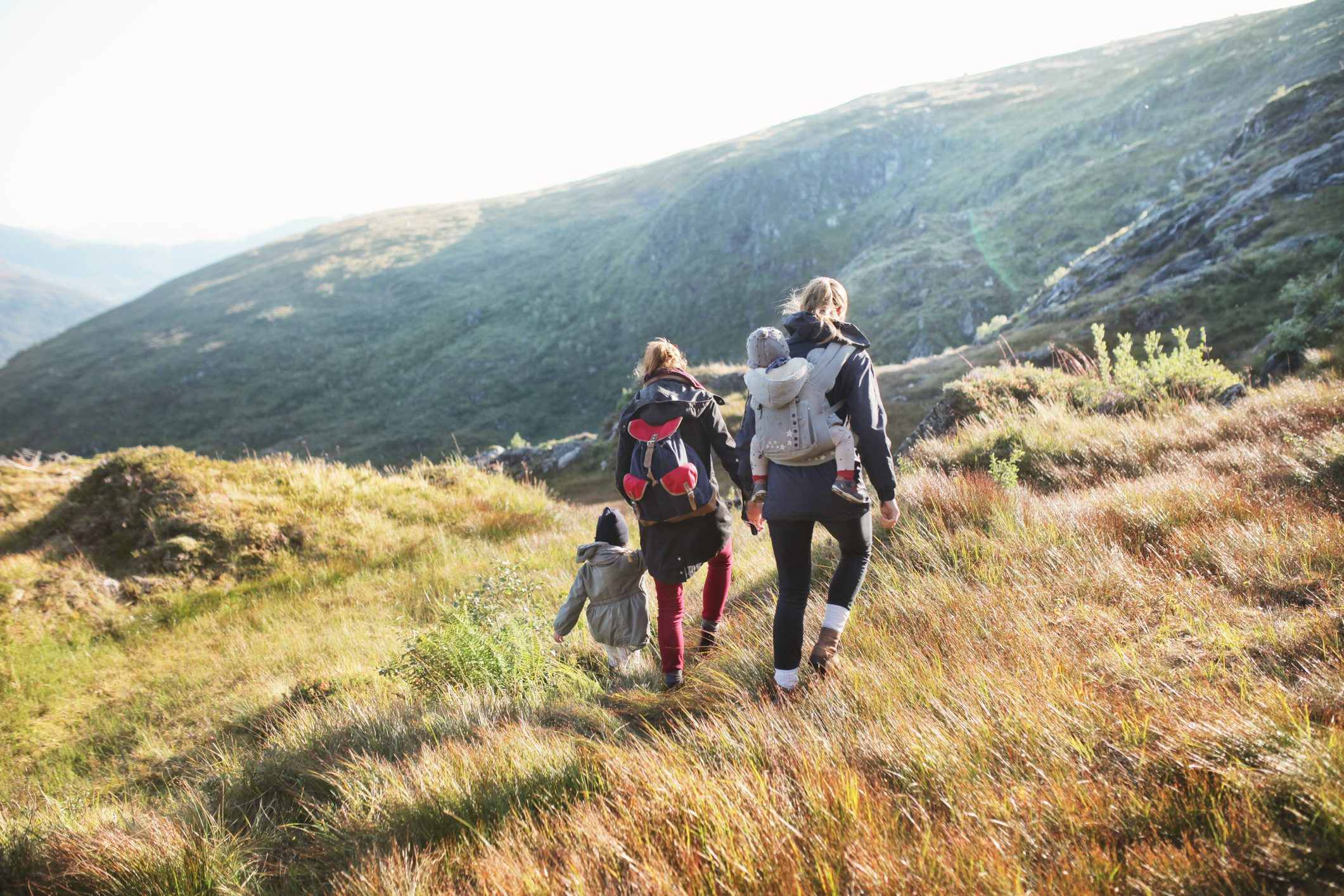 family hiking outside mountains in the background