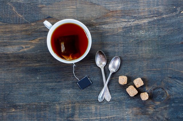 Top view of cup of tea on vintage wooden background.