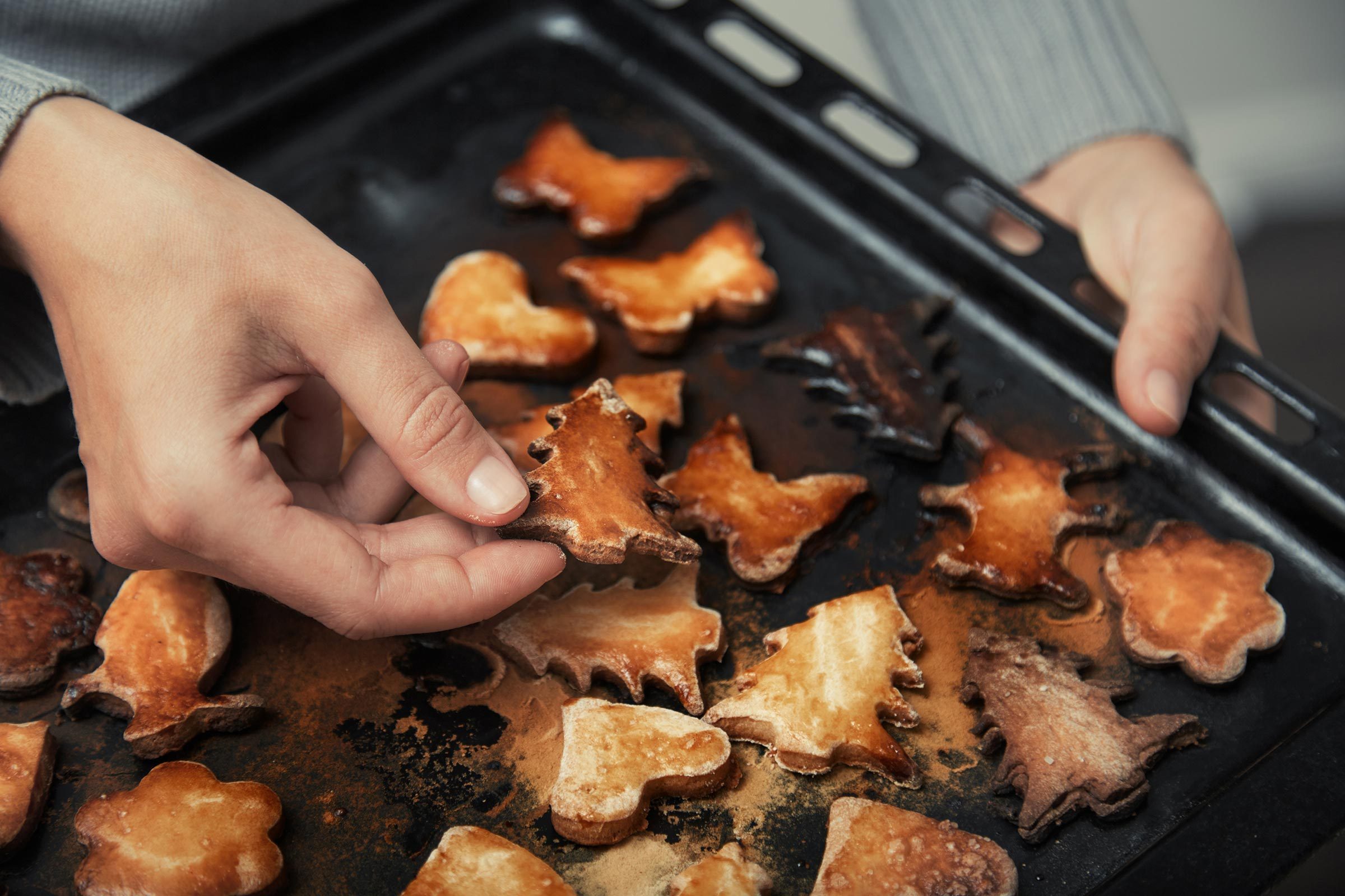 woman holding burned pan of holiday cookies