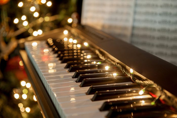 A piano with christmas lights and tree
