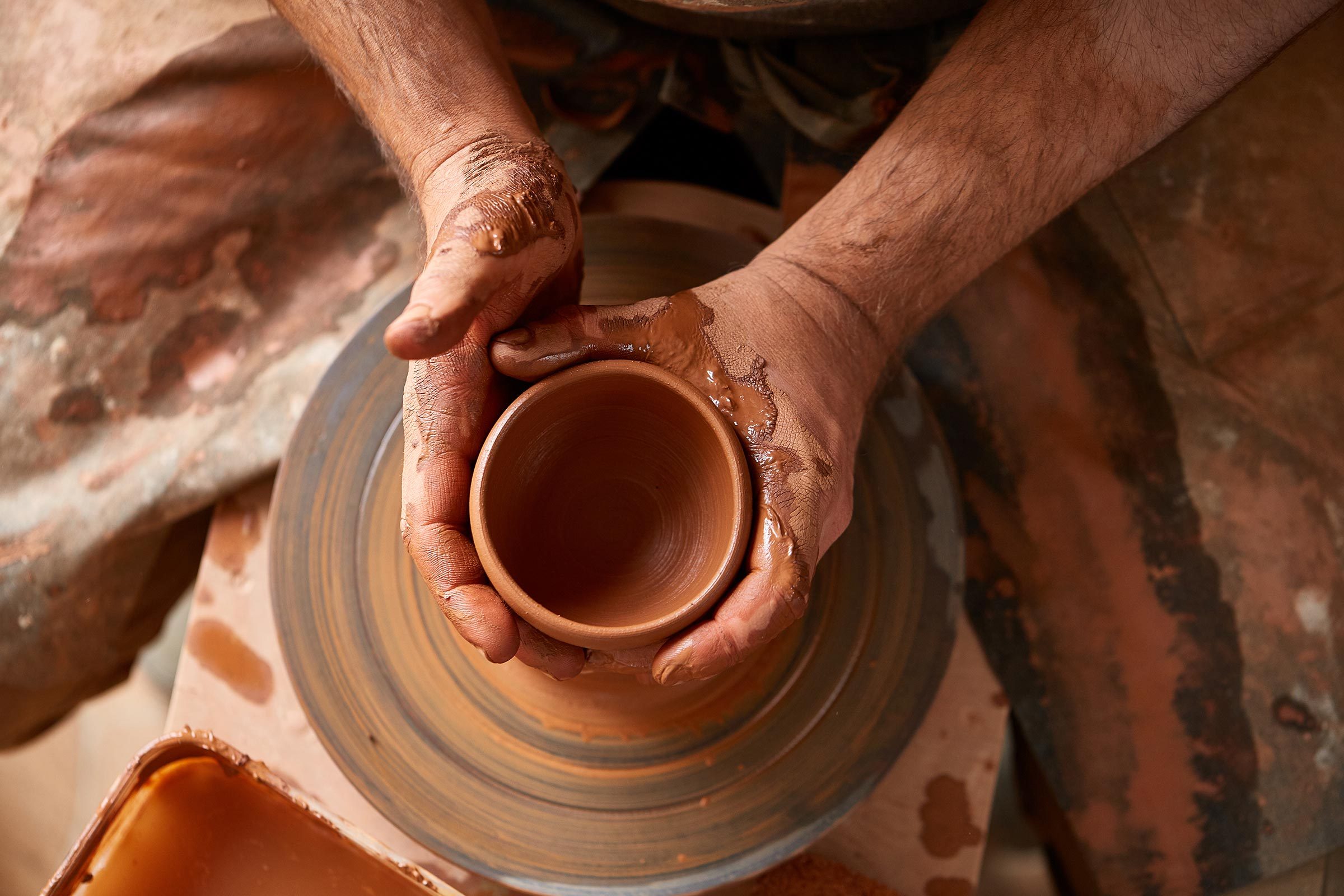 close up of hands working on a pottery wheel