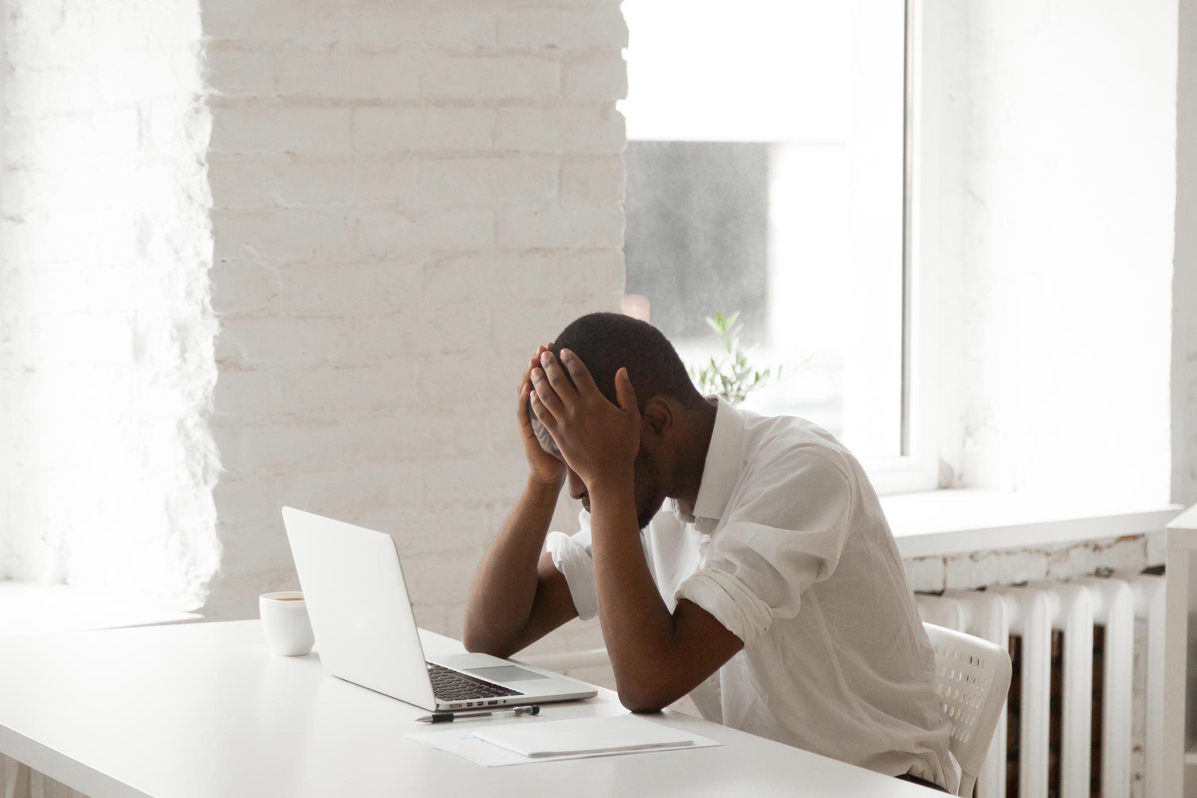 Man at his desk with his head in his hands
