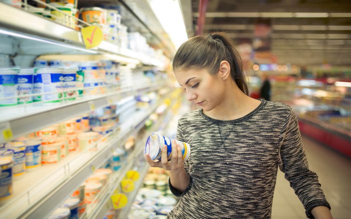 woman reading label of product at a grocery store