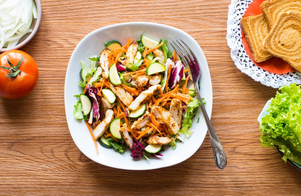 Salad of chicken breast with zucchini and cherry tomatoes, on a wooden background. top view