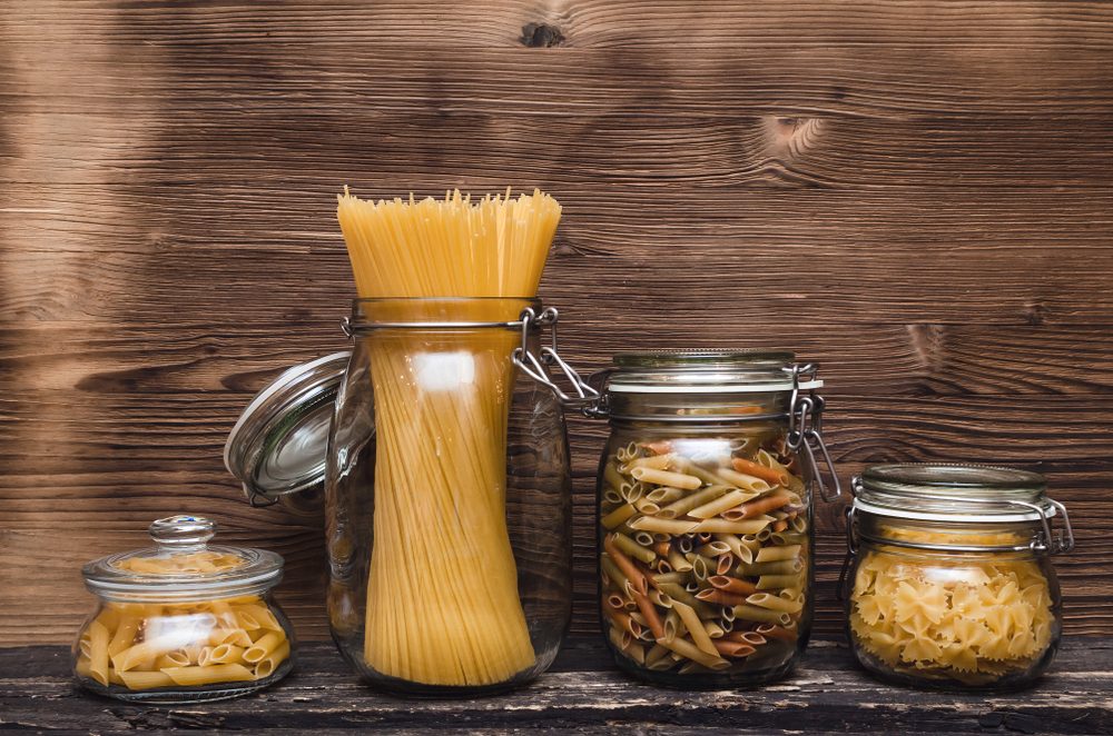 Pasta macaroni concept background. Pasta in a glass jar container.