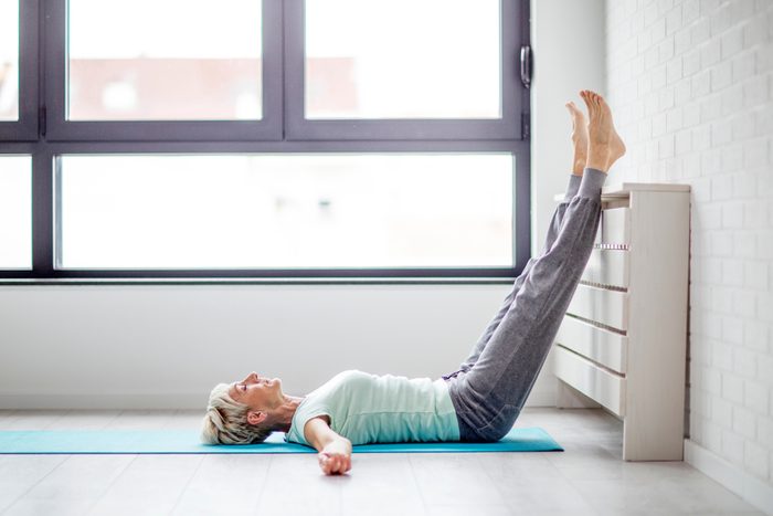 Senior beautivul woman practise joga in room