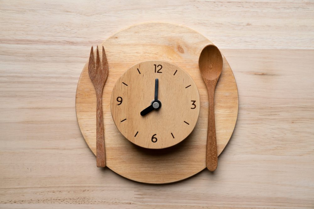 Food clock spoon and fork, Healthy food concept on wooden table background