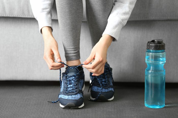 Woman tying up running shoe