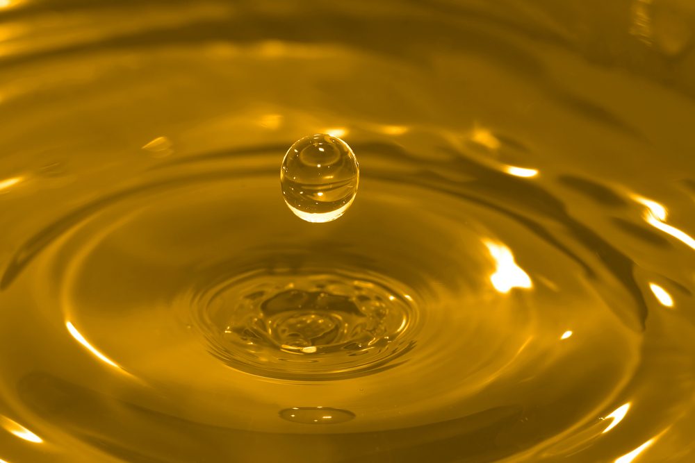 High-speed photo of a water drop frozen in time after it has impacted and rebounded a body of water.