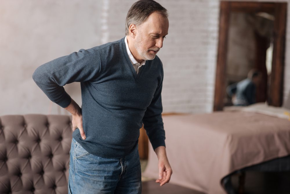 Old man standing with pain in back