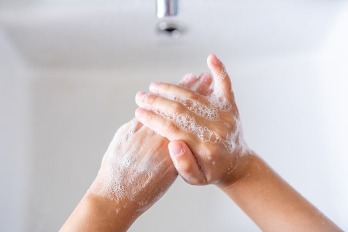 Hygiene concept. Kid washing hands with soap.