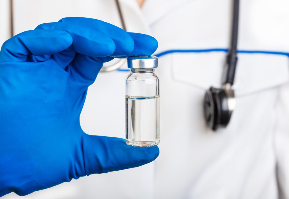 Doctor is holding glass bottle of medicine