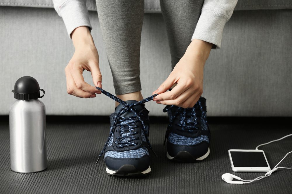 Woman tying up running shoe