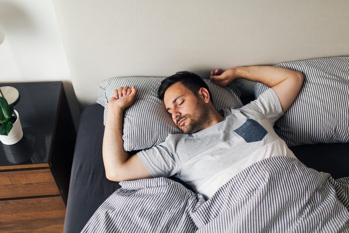 Young man sleeping alone on his back