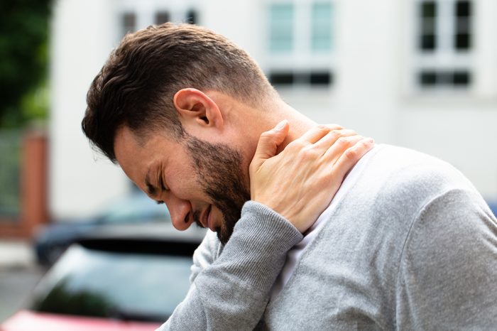 man suffering from neck pain