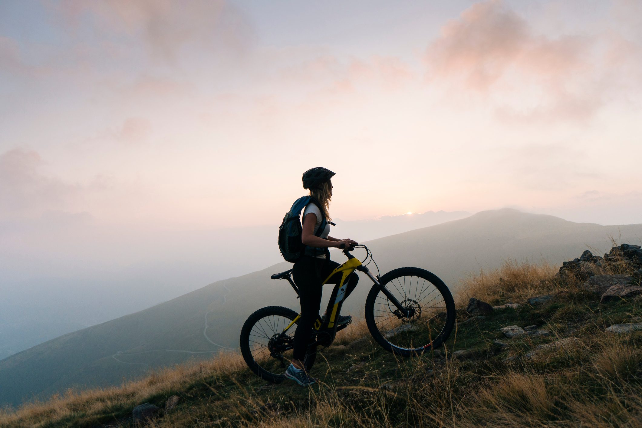 female mountain biker climbing up mountain
