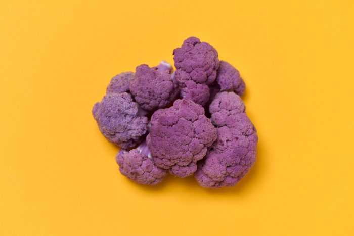 high angle view of a purple cauliflower on an orange background