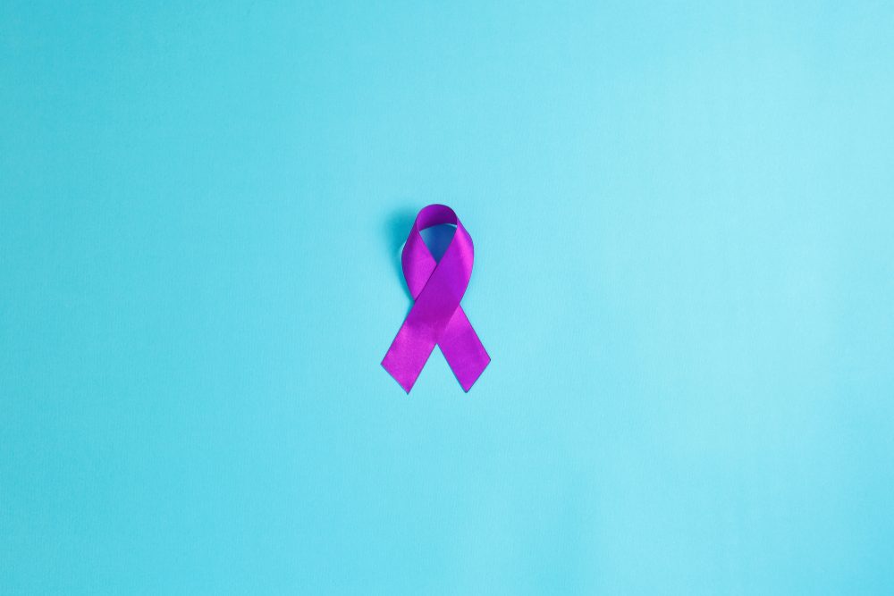 Purple ribbons on blue background, Alzheimer disease, Pancreatic cancer, Epilepsy awareness, domestic violence awareness,fibromyalgia awareness, world cancer day. copy space
