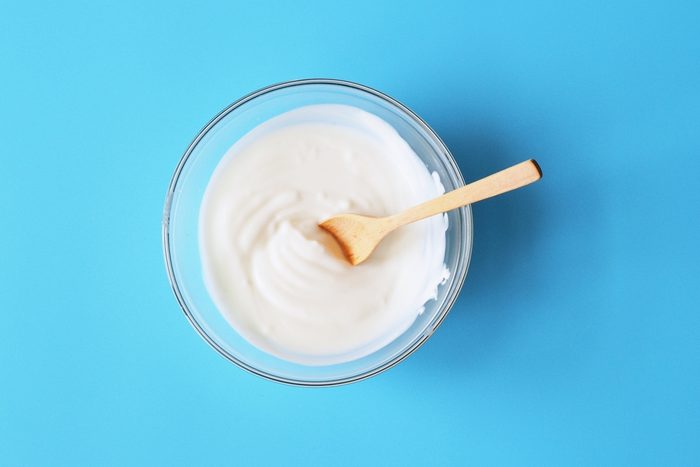 swirled yogurt In blow over blue color background.