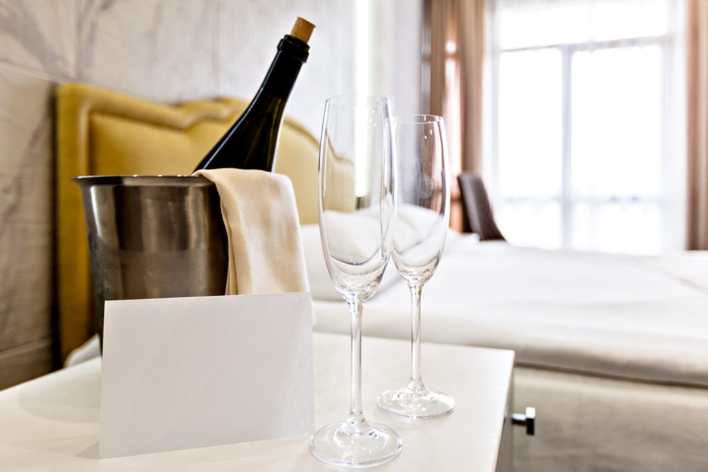 Honeymoon concept. Champagne bucket near bed in a hotel room