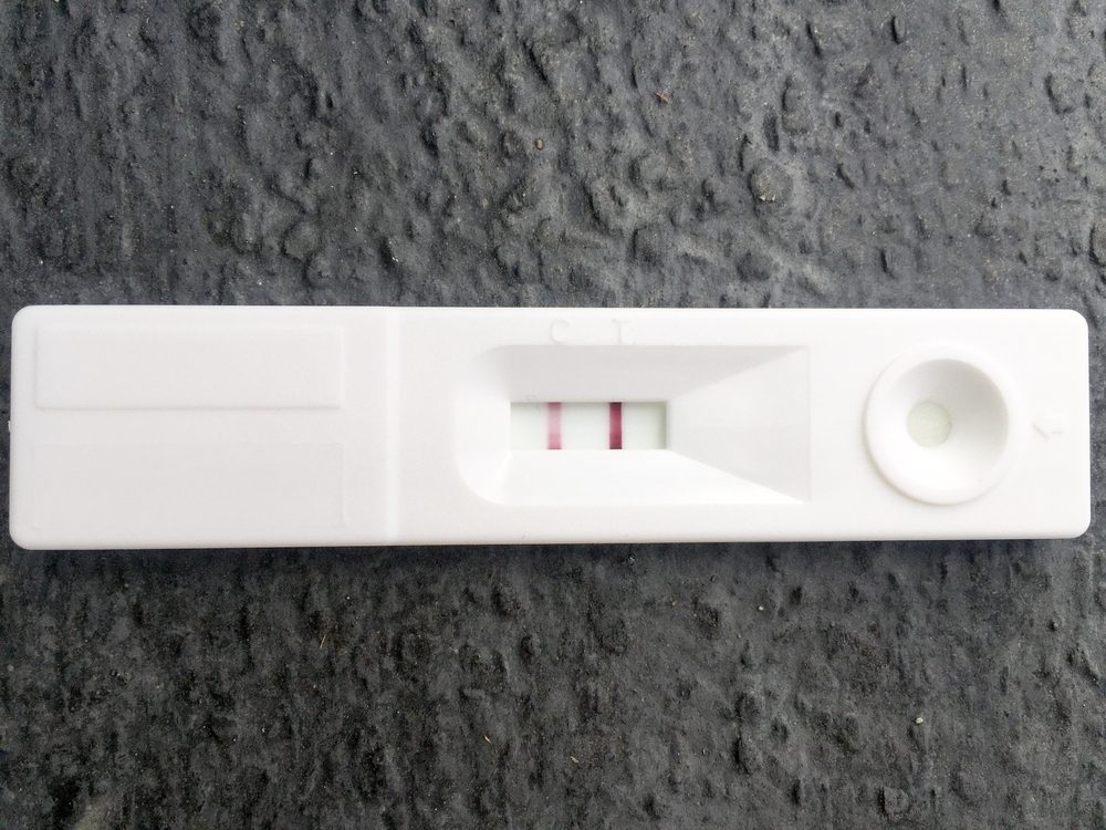 Pregnancy test on dark gray background. positive result.