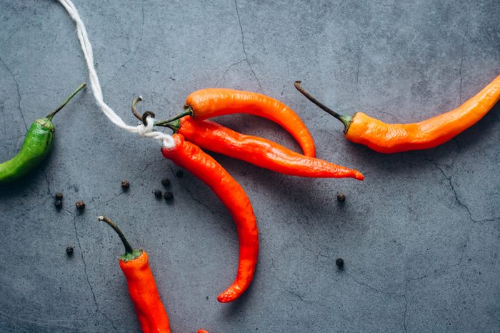 Red hot chilli chilies pepper bunch, tied by string on a gray background. Place for text