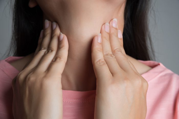 Sore Throat. Closeup Of Beautiful Young Woman Hand Touching Her Ill Neck. Healthcare and medical concept.