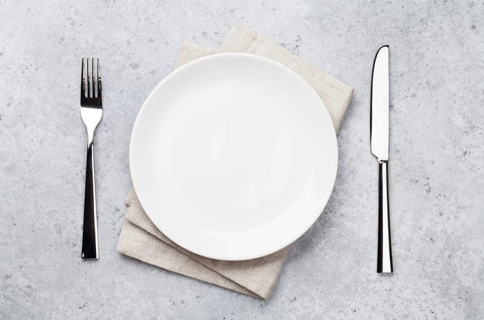 Table setting. Empty plate, knife, fork and napkin. Top view and flat lay with copy space