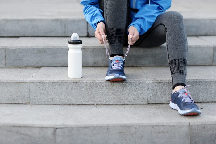 Woman runner tying laces before training. Marathon