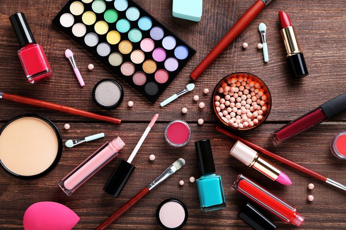 Different makeup cosmetics on brown wooden table