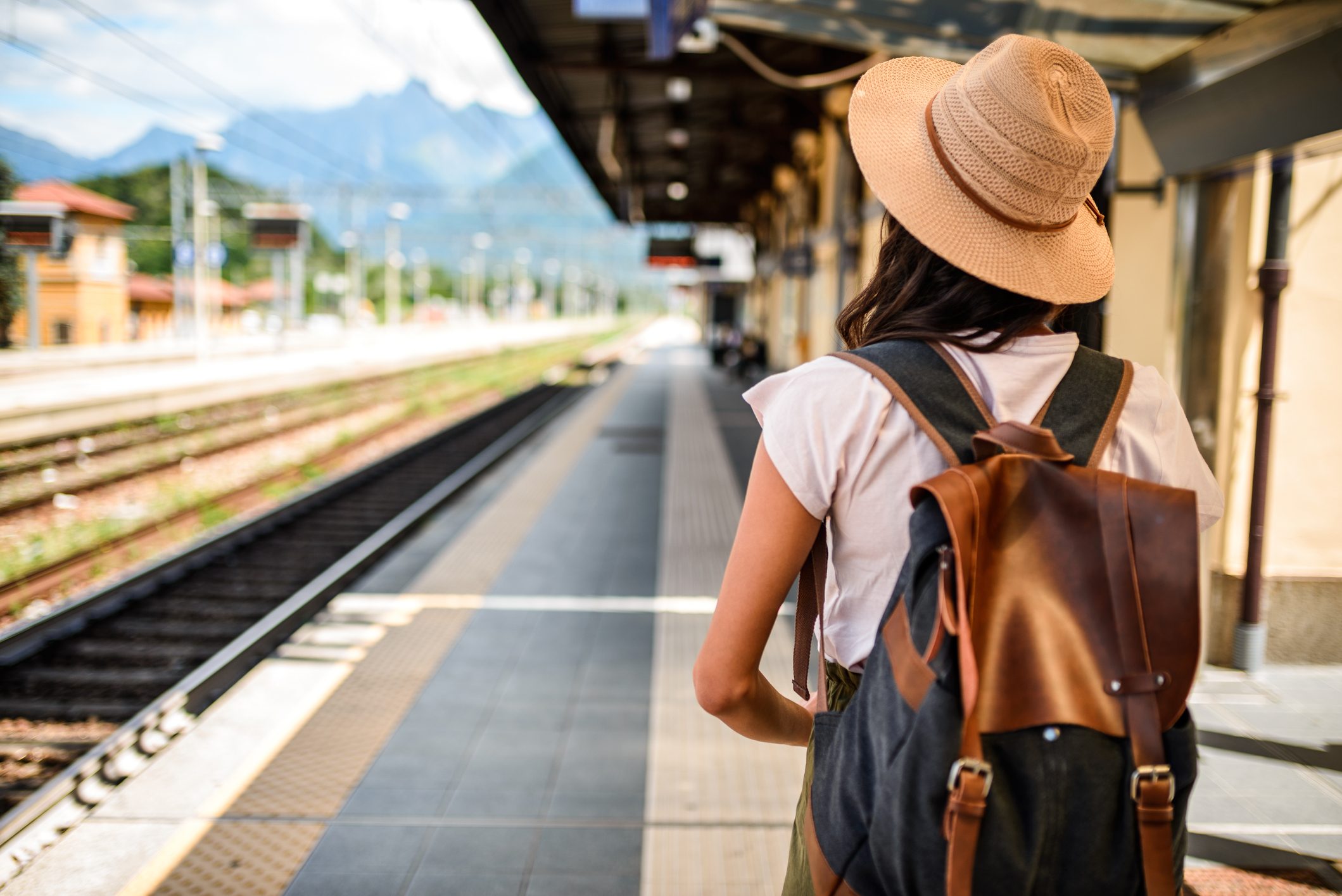 rear view of young woman waiting for train to arrive