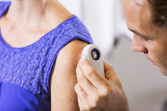dermatologist examining woman's skin