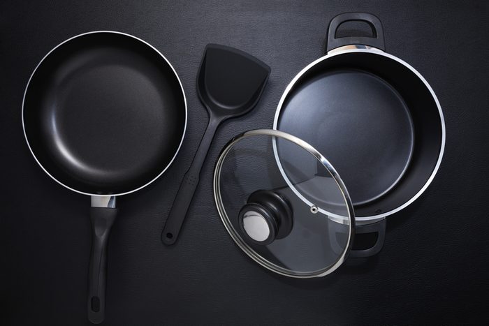 Top view frying pan and pot on black table