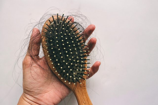 Hair loss inside wood comb brush, on hand