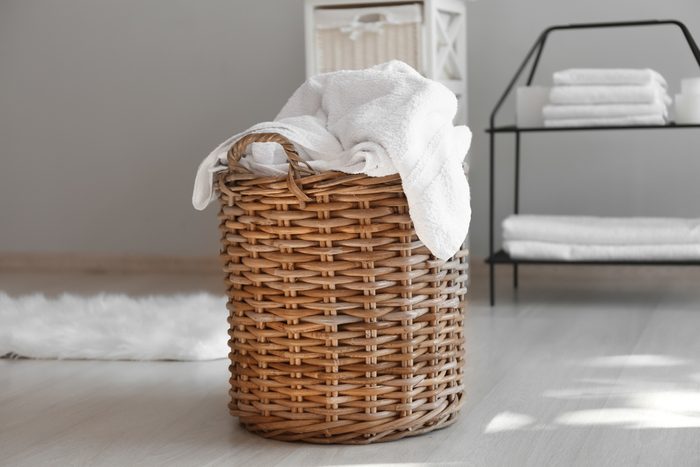 Laundry basket with dirty towels on floor