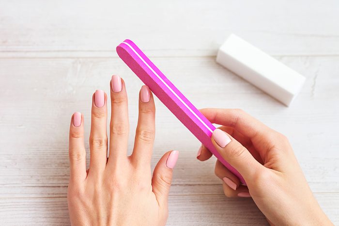 woman filling nails