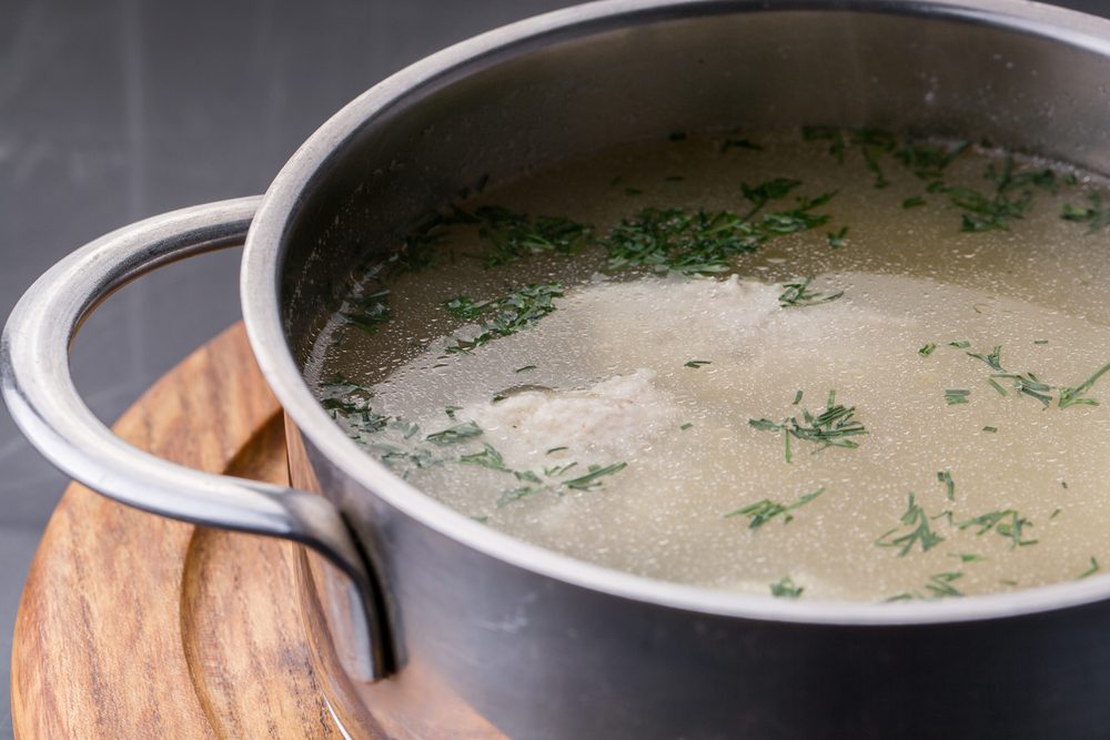 an image of Chicken bouillon with vegetables and spices in a metal pot