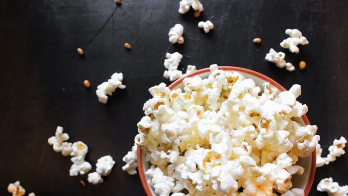 Popcorn in bowl on black background.