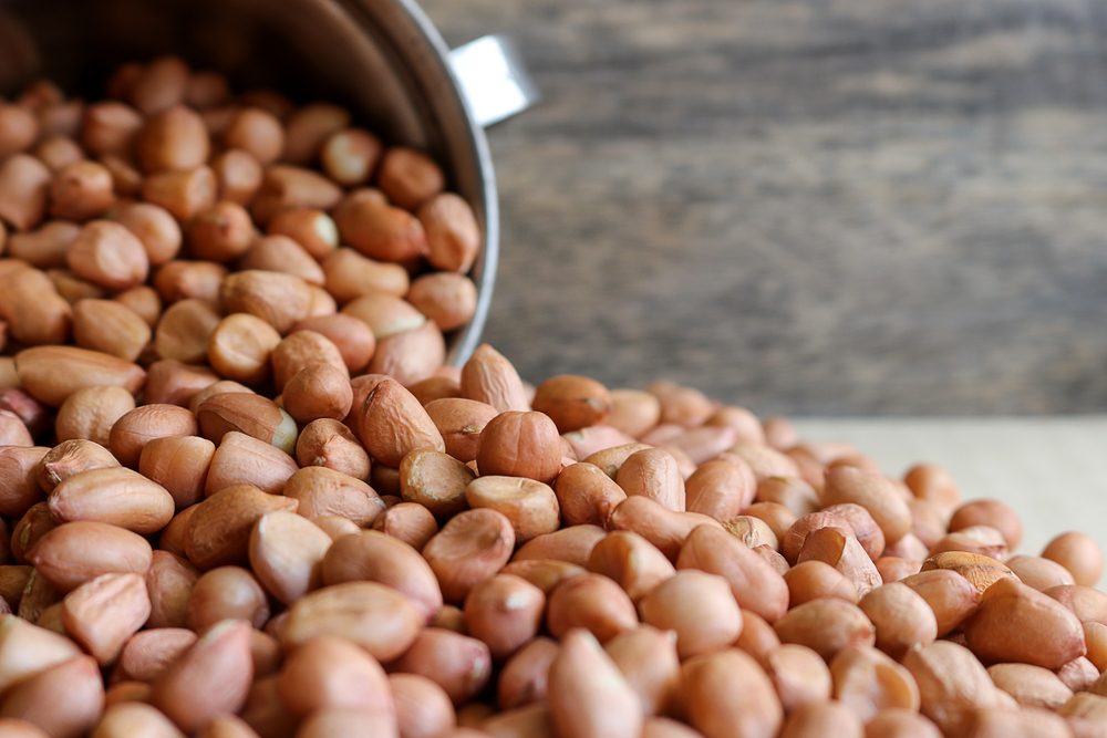 Peanuts in stainless cup on wooden background. Peanuts are rich in energy and anti-ageing. Nuts can prevent coronary artery disease, Cancer, Diabetes, Gallstones and improves memory.