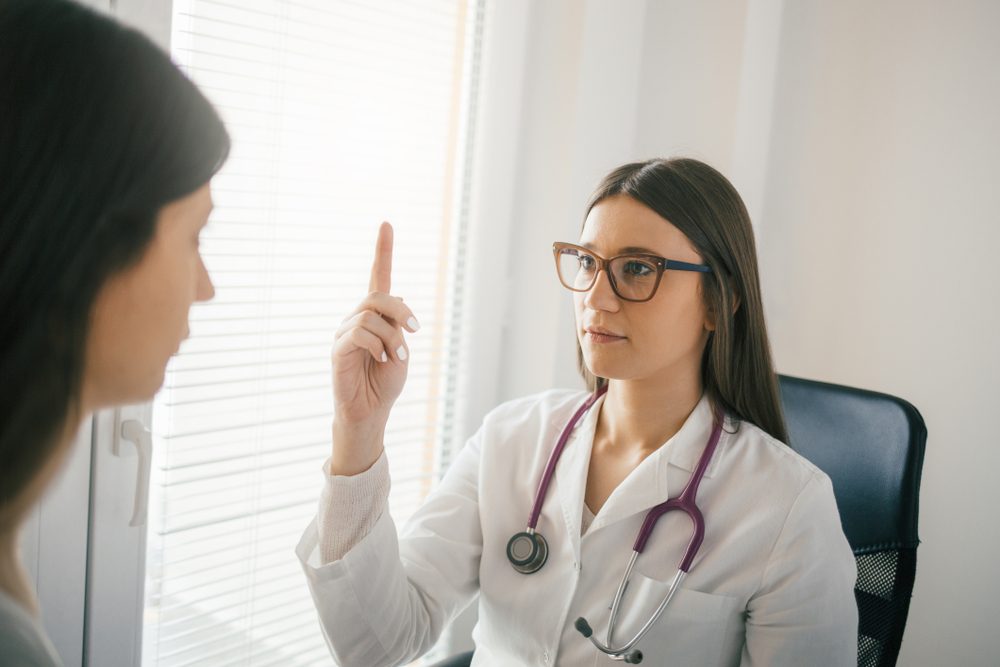 Female doctor examining a patient's eye reflex and accommodation. Medical examination, clinic, hospital 