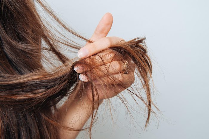 woman holding the ends of her long hair