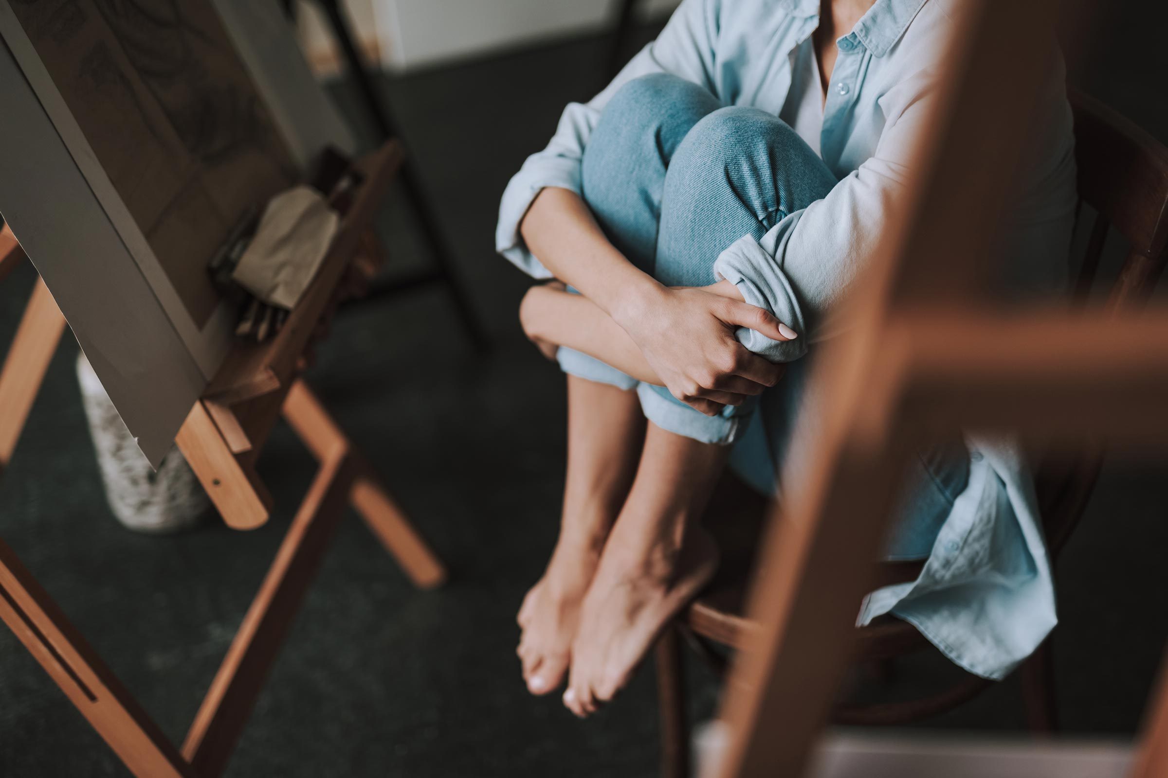 Woman hugging her knees to her chest.