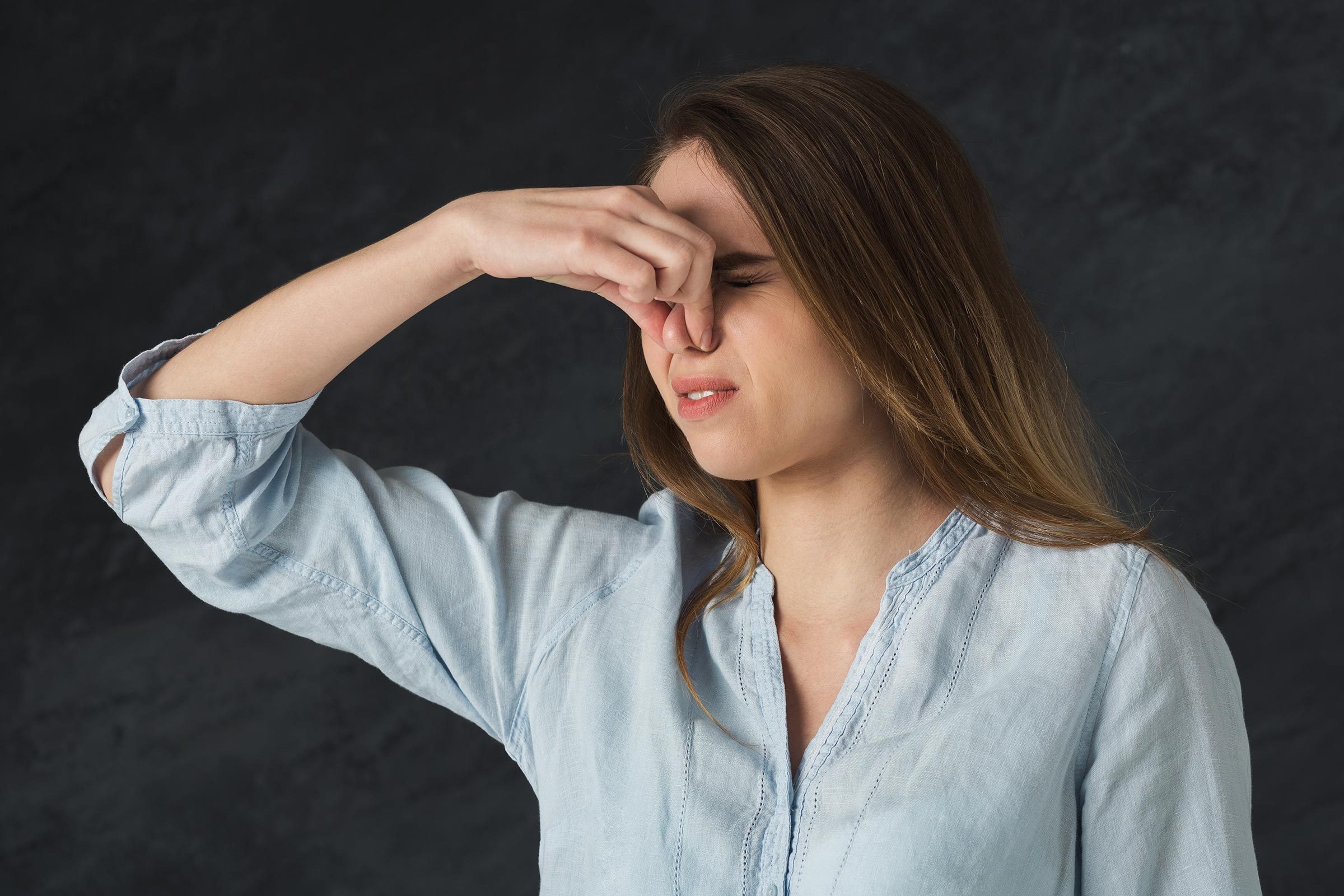 Woman pinching her nose.