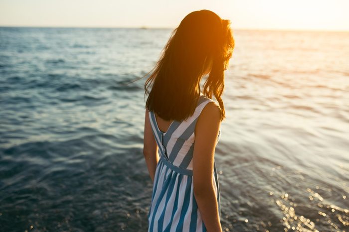 woman sun flare beach water