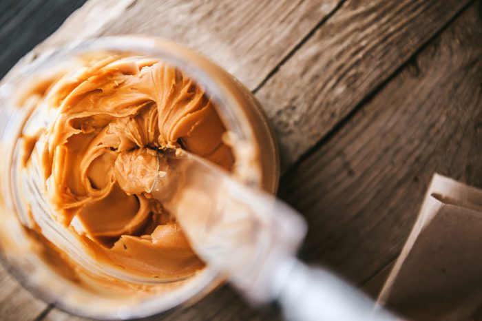 overhead view of knife inside peanut butter jar