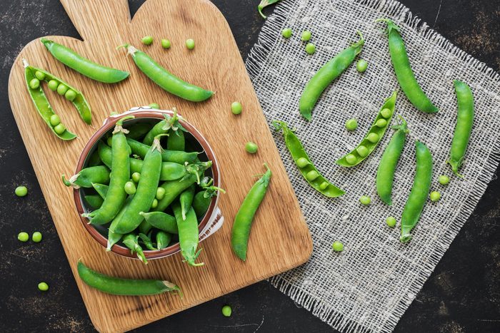 Green peas in a bowl on a dark rustic background,flat lay. Vegetarian food. The view from the top