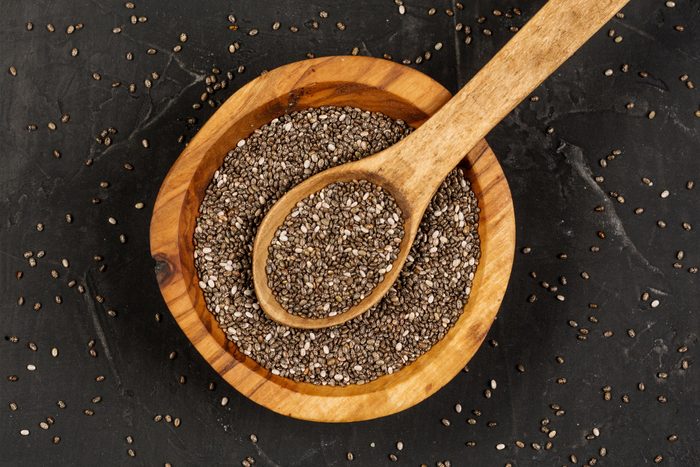 Chia seeds in organic dish n dark background. Top view